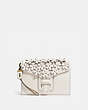 COACH®,COURIER WRISTLET WITH FLORAL APPLIQUE,Smooth Leather,Brass/Chalk,Front View