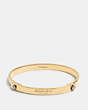 COACH®,DAISY RIVET COACH TENSION BANGLE,Mixed Metal,Gold,Front View