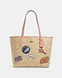 COACH®,DISNEY X COACH CITY TOTE IN SIGNATURE CANVAS WITH PATCHES,Large,Gold/Light Khaki Multi,Front View