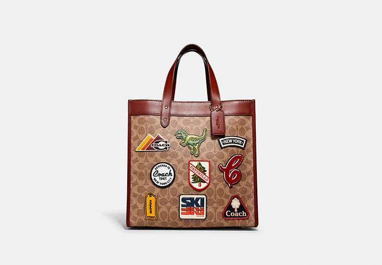 COACH®,FIELD TOTE IN SIGNATURE CANVAS WITH PATCHES,Signature Coated Canvas/Smooth Leather,Medium,Brass/Tan/Rust,Front View