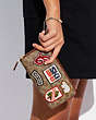COACH®,ACCORDION ZIP WALLET IN SIGNATURE CANVAS WITH PATCHES,Brass/Tan/Rust,Detail View