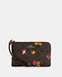 COACH®,CORNER ZIP WRISTLET IN SIGNATURE CANVAS WITH ORNAMENT PRINT,Gold/Brown Black Multi,Front View