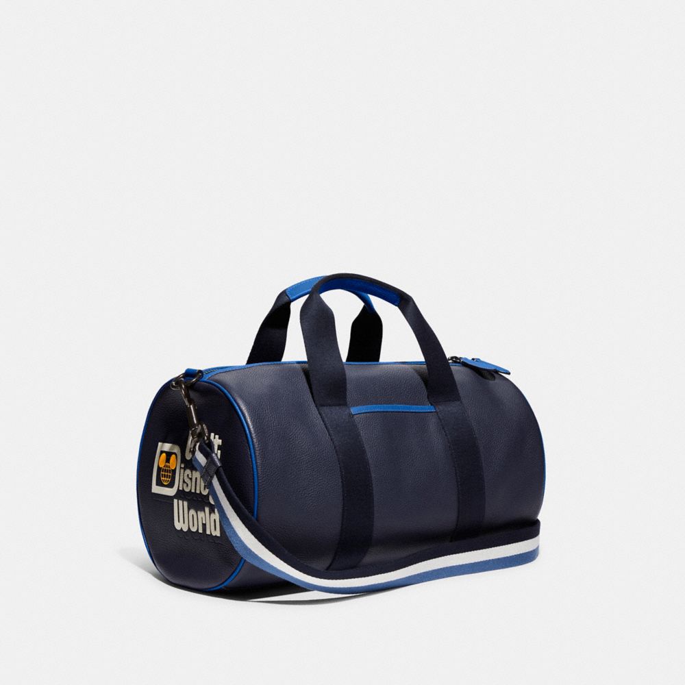 COACH®,DISNEY X COACH DUFFLE WITH WALT DISNEY WORLD MOTIF,Polished Pebble Leather,Medium,Black Copper/Midnight Navy Multi,Angle View