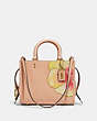 COACH®,COACH X KŌKI, ROGUE BAG 25 IN ORIGINAL NATURAL LEATHER WITH PANSY,Leather,Medium,Brass/Buff,Front View