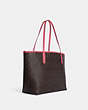 COACH®,CITY TOTE BAG IN SIGNATURE CANVAS WITH VARSITY MOTIF,Signature Coated Canvas,Large,Im/Brown/Watermelon,Angle View