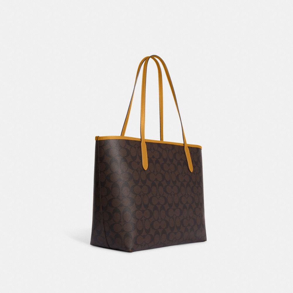 COACH®,CITY TOTE BAG IN SIGNATURE CANVAS WITH VARSITY MOTIF,Large,Black Antique Nickel/Brown/Buttercup,Angle View
