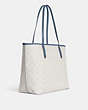 COACH®,CITY TOTE IN SIGNATURE CANVAS WITH VARSITY MOTIF,Signature Coated Canvas,Large,Silver/Chalk/Indigo,Angle View