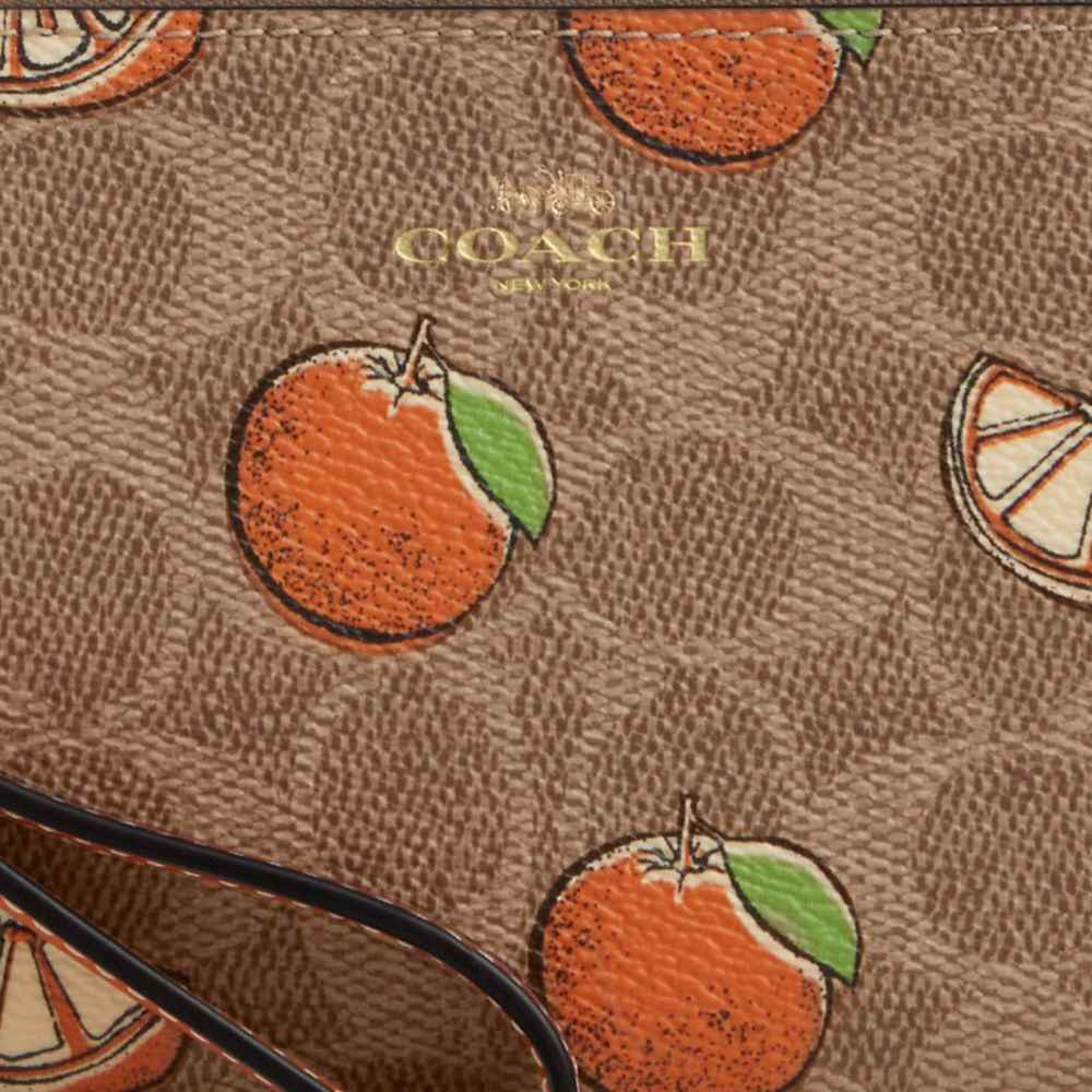 COACH®,Corner Zip Wristlet In Signature Canvas With Orange Print,,Closer View