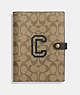 COACH®,NOTEBOOK IN SIGNATURE CANVAS WITH VARSITY MOTIF,Im/Khaki Amazon Green Multi,Front View