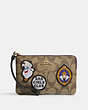 COACH®,DISNEY X COACH CORNER ZIP WRISTLET IN SIGNATURE CANVAS WITH PATCHES,Signature Coated Canvas,Gold/Khaki Multi,Front View