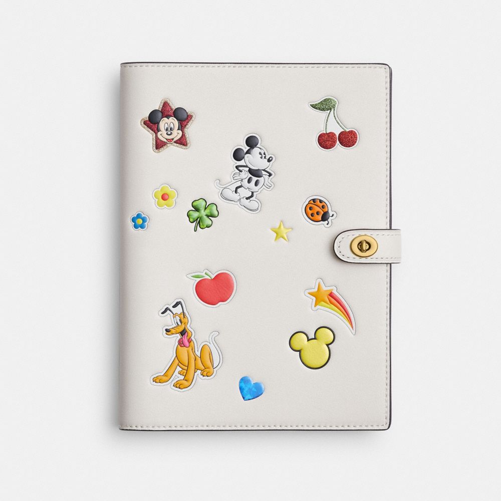 COACH®,Disney X Coach Notebook With Sticker Print,Leather,Notebook,Paper,Stitching,Graphic,Brass,White,Front View