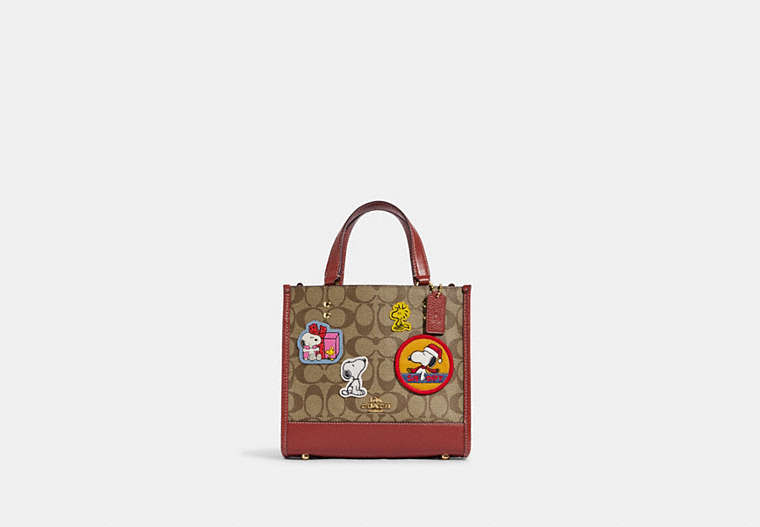 COACH®,COACH X PEANUTS DEMPSEY TOTE 22 IN SIGNATURE CANVAS WITH PATCHES,Signature Coated Canvas,Medium,Gold/Khaki/Redwood Multi,Front View