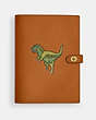COACH®,NOTEBOOK WITH REXY,Glovetanned Leather,Brass/Hazelnut,Front View
