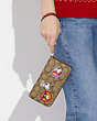 COACH®,COACH X PEANUTS LONG ZIP AROUND WALLET IN SIGNATURE CANVAS WITH PATCHES,Signature Coated Canvas,Mini,Gold/Khaki/Redwood Multi,Detail View