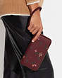 COACH®,LONG ZIP AROUND WALLET WITH HOLIDAY BELLS PRINT,Printed Coated Canvas,Mini,Gold/Black Cherry Multi,Detail View