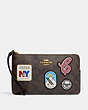 COACH®,LARGE CORNER ZIP WRISTLET IN SIGNATURE CANVAS WITH SKI PATCHES,Mini,Gold/Brown Black Multi,Front View