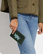 COACH®,CORNER ZIP WRISTLET WITH TAURUS,Polished Pebble Leather,Mini,Silver/Amazon Green Multi,Detail View