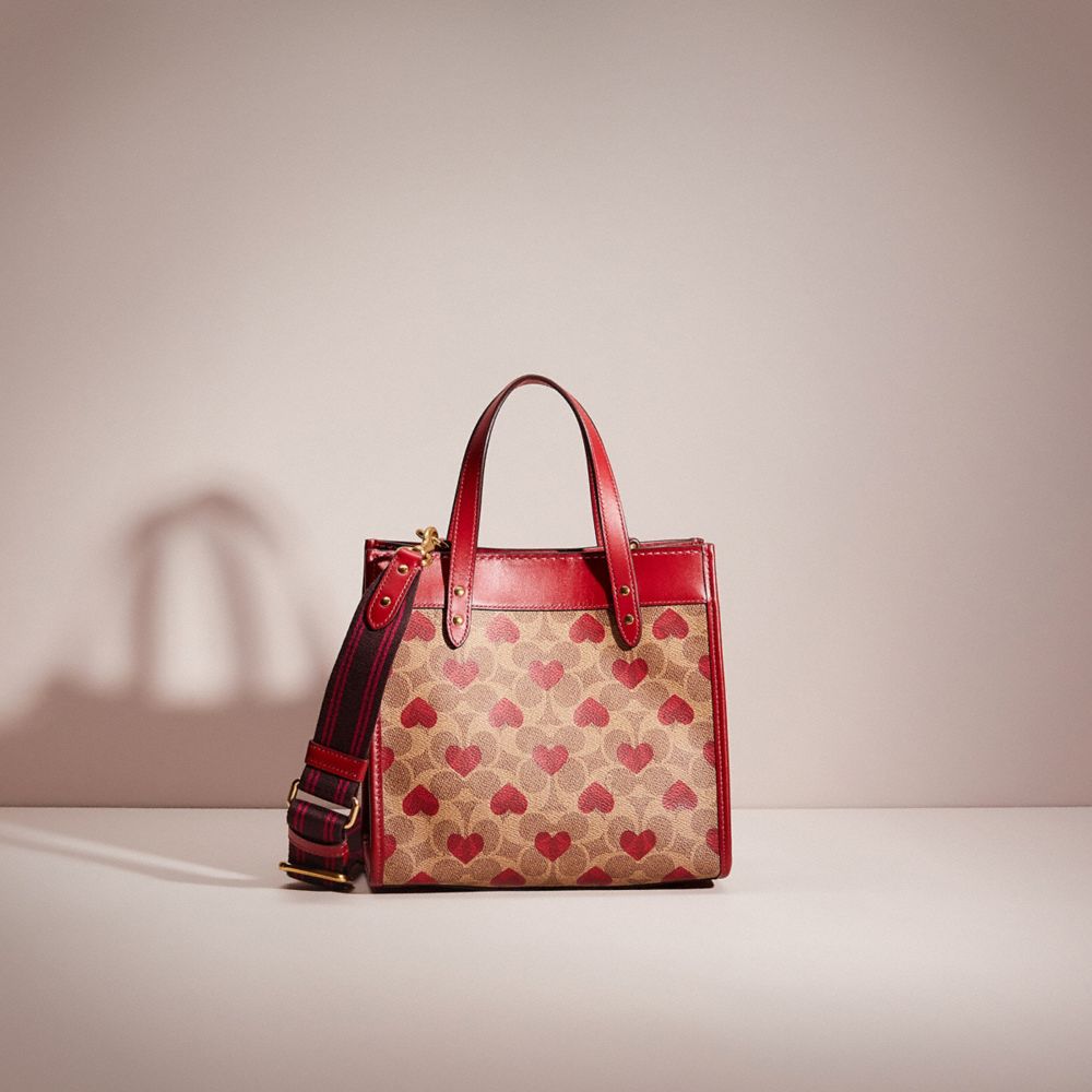 COACH®,RESTORED  FIELD TOTE 22 IN SIGNATURE CANVAS WITH HEART PRINT,Signature Coated Canvas,Medium,Brass/Tan Red Apple,Front View