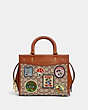 COACH®,DISNEY X COACH ROGUE 25 IN SIGNATURE TEXTILE JACQUARD WITH PATCHES,Jacquard,Medium,Brass/Cocoa Burnished Amber Multi,Front View