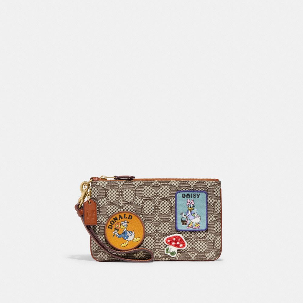 COACH®,DISNEY X COACH SMALL WRISTLET IN SIGNATURE TEXTILE JACQUARD WITH PATCHES,Signature Jacquard,Mini,Brass/Cocoa Burnished Amb,Front View