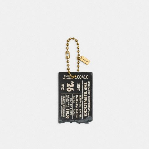 Женский брелок Coach The Turnlocks Concert Ticket Bag Charm, цвет: Латунный / Чёрный