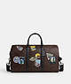 COACH®,VENTURER BAG IN SIGNATURE CANVAS WITH TRAVEL PATCHES,pvc,X-Large,Gunmetal/Mahogany Multi,Front View