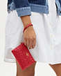 COACH®,BOXED CORNER ZIP WRISTLET IN SIGNATURE LEATHER,Embossed Leather,Mini,Gold/Electric Red,Detail View