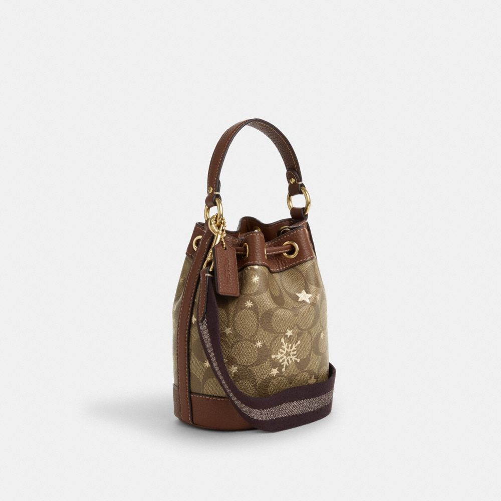 COACH®,DEMPSEY DRAWSTRING BUCKET BAG 15 IN SIGNATURE CANVAS WITH STAR AND SNOWFLAKE PRINT,Signature Canvas,Medium,Im/Khaki Saddle/Gold Multi,Angle View
