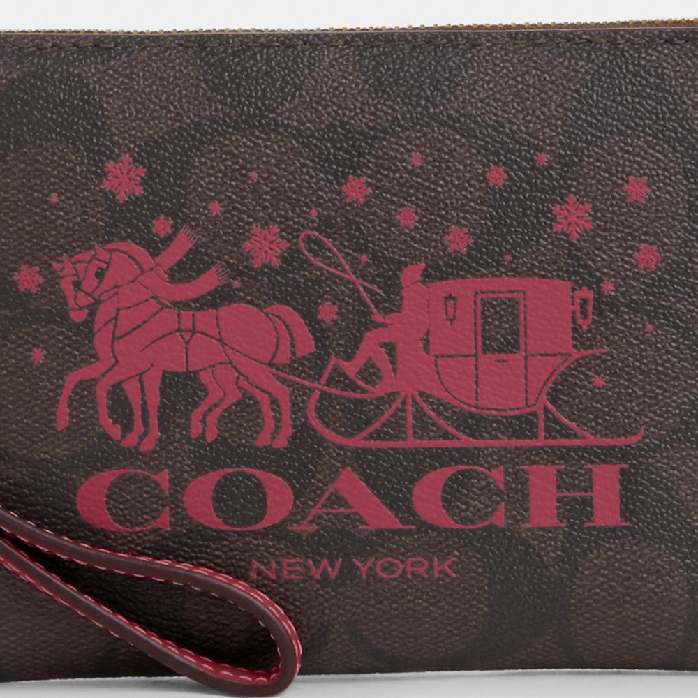 COACH®,CORNER ZIP WRISTLET IN SIGNATURE CANVAS WITH HORSE AND SLEIGH,Signature Canvas,Mini,Im/Brown/Rouge