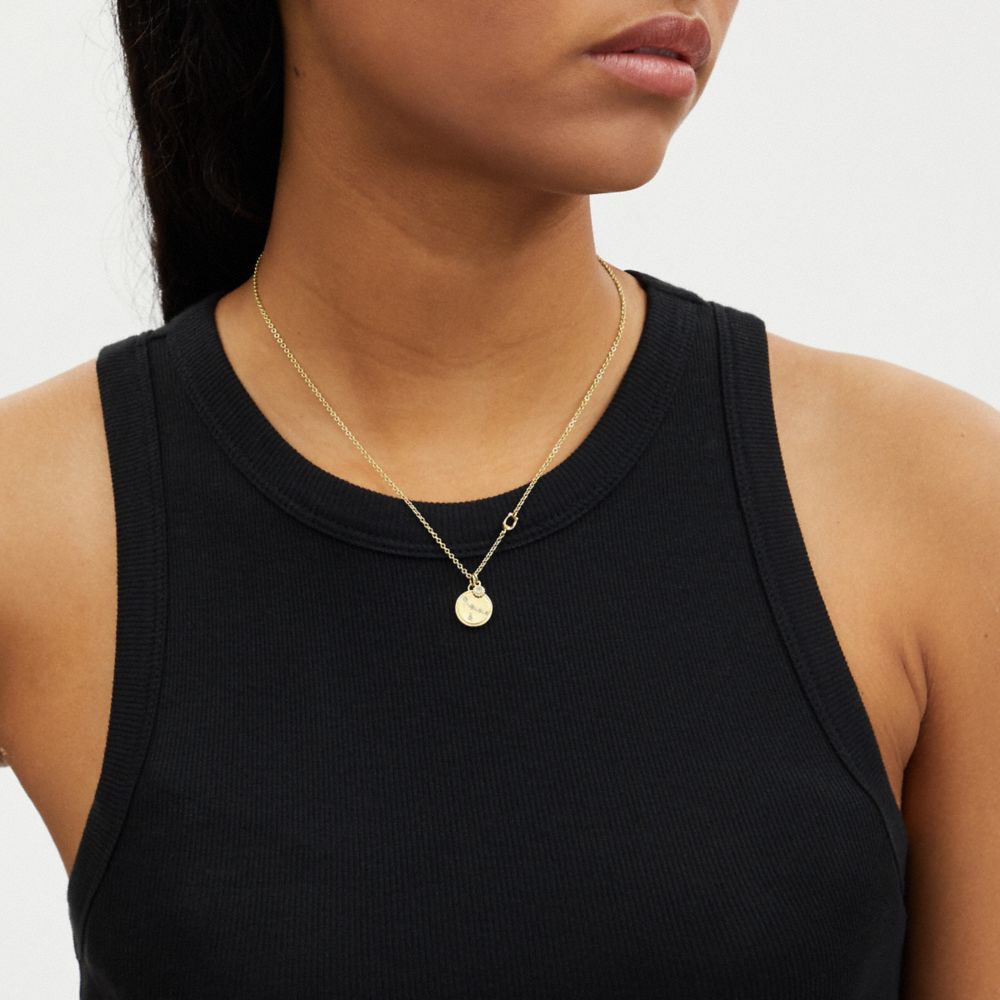 COACH®,Cancer Coin Pendant Necklace,Single Strand,Cubic Zirconia,Glass,Bead Embellishment,Disc,Lettering Word,Logo,Rhinest...,Clear,Detail View