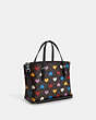 COACH®,MOLLIE TOTE 25 IN SIGNATURE CANVAS WITH HEART PRINT,pvc,Medium,Silver/Brown Black Multi,Angle View