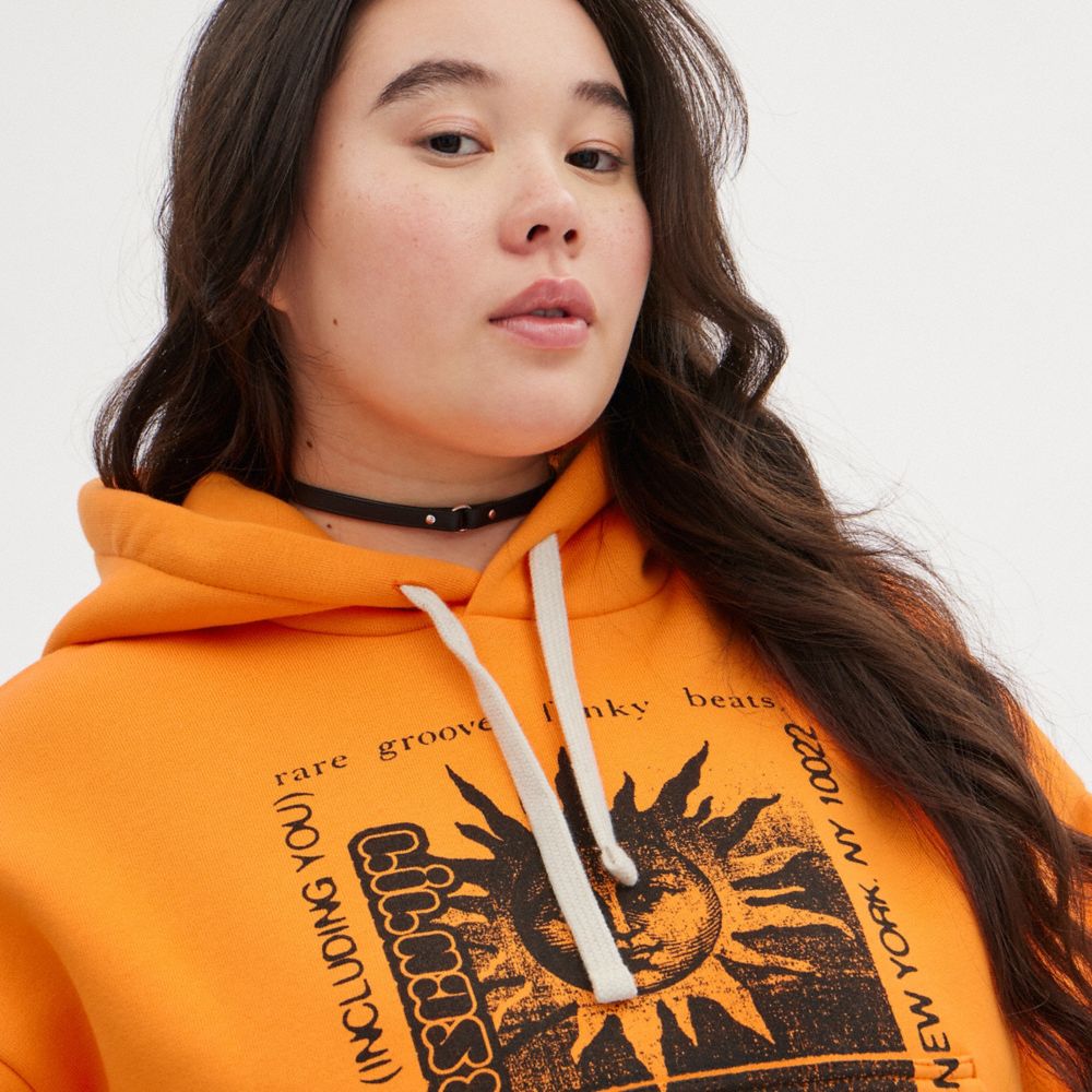 COACH®,The Lil Nas X Drop Cropped Pullover Hoodie,Polyester,Elastane,Cotton,Knit,Sweatshirt,Word Embellishment,Drawstring,...,Orange,Detail View