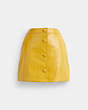 COACH®,PATENT LEATHER MINI SKIRT,Yellow,Front View