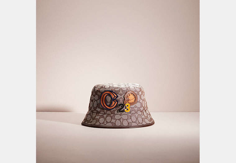 COACH®,UPCRAFTED SIGNATURE JACQUARD BUCKET HAT IN ORGANIC COTTON AND RECYCLED POLYESTER,School Spirit,Stone 1941 Saddle,Front View