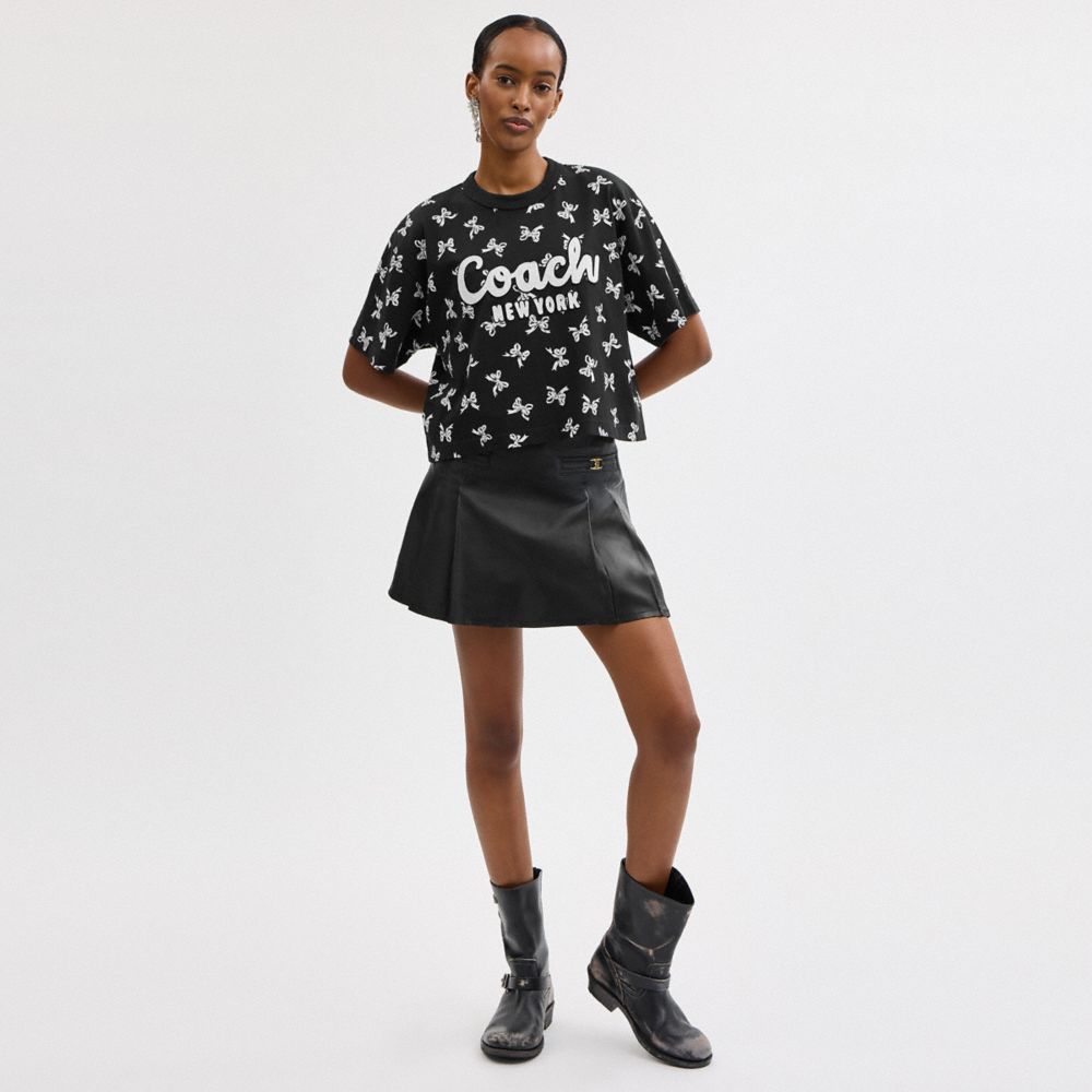 COACH®,T-SHIRT COURT AVEC SIGNATURE EN CURSIVE ET IMPRIMÉ REPRÉSENTANT DES BOUCLES,Noir,Scale View