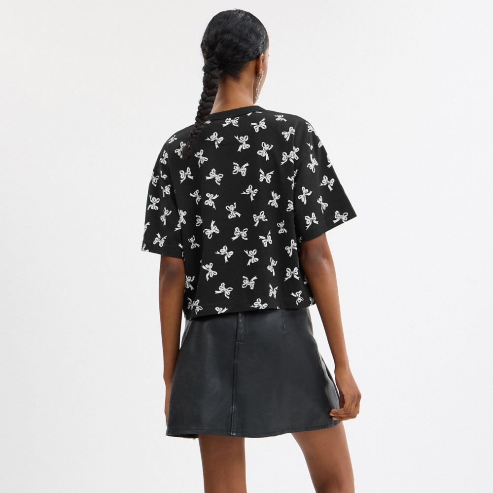 COACH®,T-SHIRT COURT AVEC SIGNATURE EN CURSIVE ET IMPRIMÉ REPRÉSENTANT DES BOUCLES,Noir,Scale View