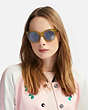 COACH®,HORSE AND CARRIAGE HOLOGRAM SUNGLASSES,Mixed Material,Yellow Trans/Li Blue Solid,Angle View